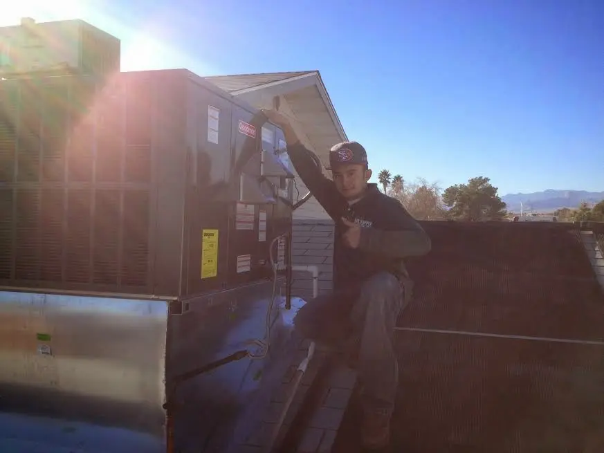 HVAC technician performing HVAC Inspection on a rooftop unit in Mitchellville